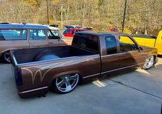 a brown truck parked in a parking lot next to other cars