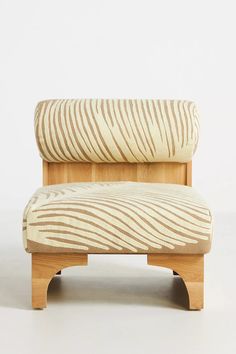 an upholstered chair with wooden legs and a zebra print seat cover on it