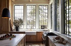 a kitchen filled with lots of counter top space next to a window covered in windows