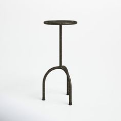 an iron table with two legs and a small round top on the bottom, against a white background