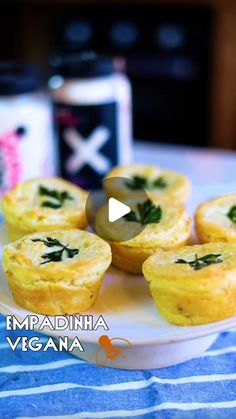 mini quiches on a white plate with green garnishes in the middle