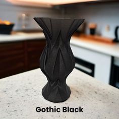 a black vase sitting on top of a kitchen counter