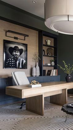 a living room with a large wooden table next to a chair and bookshelf