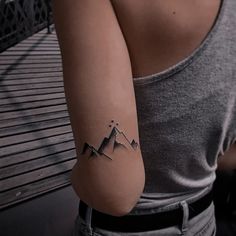 a woman with a mountain tattoo on her arm