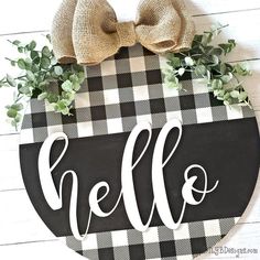 a black and white checkered door hanger with the word hello on it