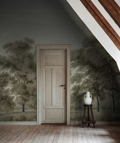 an empty room with a painting on the wall and a door to another room in front of it