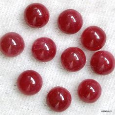 several red candies sitting on top of a white surface