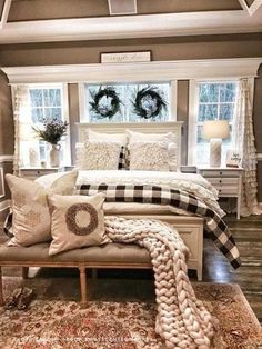 a white bed sitting in a bedroom on top of a wooden floor next to a window