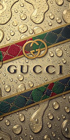 the gucci logo is on top of some water droplets and gold foiled paper