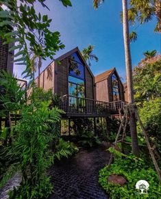 the house is surrounded by lush vegetation and trees