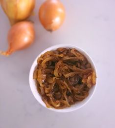 onions are in a small bowl next to garlic and onion on a white countertop