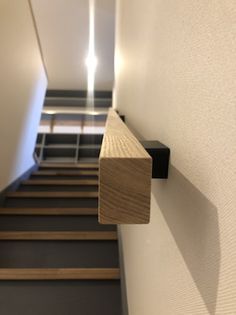 a wooden object is hanging on the wall next to some stairs