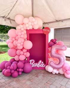 there is a pink and purple balloon arch on the ground