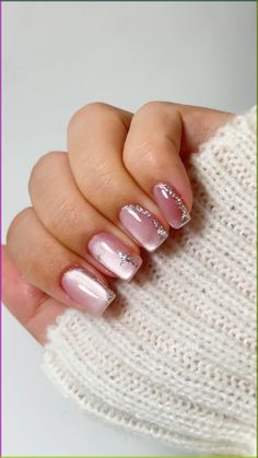 a woman's hand with some pink and white nail polishes on her nails