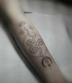 a tattoo on the arm of a person with a snake and sun in the background