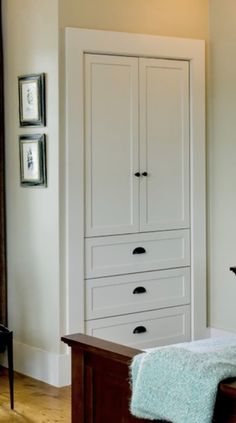 a white armoire with drawers in a room