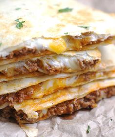 three quesadillas stacked on top of each other with melted cheese and meat