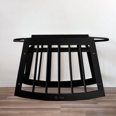 a wooden table with metal bars on the top and bottom, in front of a white wall