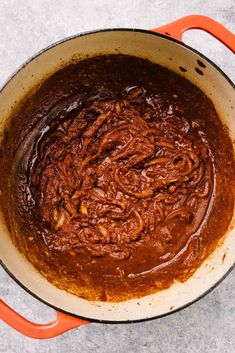 a pot filled with brown sauce sitting on top of a counter