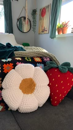 a crocheted flower sits on the back of a bed with pillows and blankets