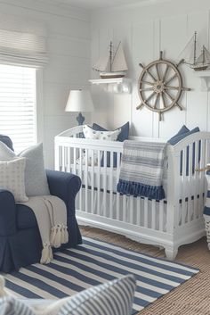 a baby's room with blue and white decor, including a ship wheel on the wall