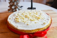 a cake with white frosting and sprinkles sitting on top of a wooden table