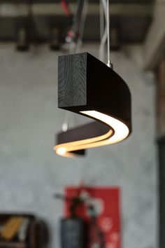 a black square light hanging from a ceiling