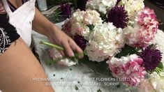 a woman is arranging flowers on a table