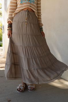 A boho closet isn't complete without the perfect maxi skirt and you can't choose a better style than the Sardinia Silky Tiered Maxi Skirt! So chic, You'll love the style of this show - stopping skirt because it features: Pretty silky Rayon gauze fabric (slightly sheer) Relaxed and loose maxi skirt silhouette High - rise waistline with an elastic drawstring waistband with tassel beaded details Gathered tiers throughout for added movement and style Short lining for added coverage Pair with: Lace E Tiered Skirt Outfit, Boho Closet, Boho Essentials, Maxi Skirts Summer, Bralette Outfit, Tiered Maxi Skirt, Denim Day, Better Style, Thrift Finds