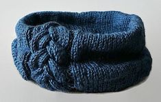 a blue knitted headband with the word pattern written below it in white letters