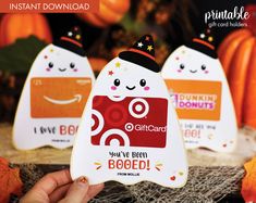 someone is holding up some cute little stickers for their business card holders, with pumpkins in the background