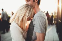 a man and woman kissing each other on the street