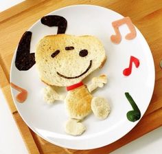 a white plate topped with a piece of bread covered in music notes and a dog