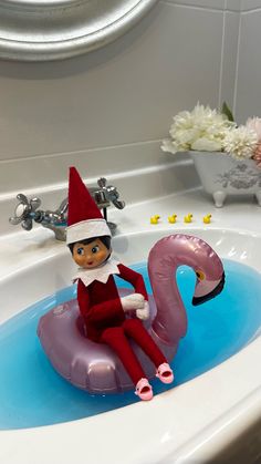 the elf is sitting on an inflatable flamingo