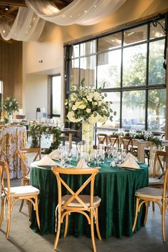 the tables are set with green linens and white flowers