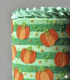 a green cake with orange pumpkins on it