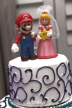 a wedding cake with mario and princess peach on top