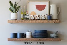 two wooden shelves with cups and plates on them