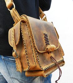 a man is holding a brown leather bag