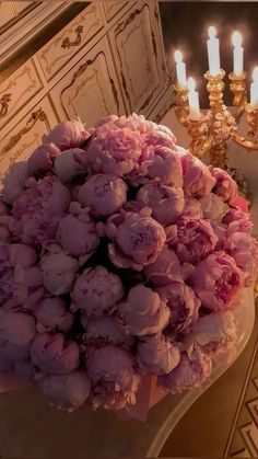 a bouquet of flowers sitting on top of a table next to a chandelier