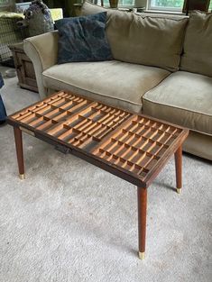 a living room with a couch, coffee table and window in the backround