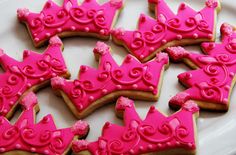 some pink decorated cookies on a white plate