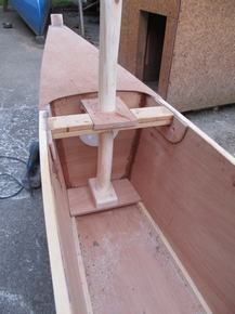 a wooden boat is being built on the ground in a yard with other woodworking tools