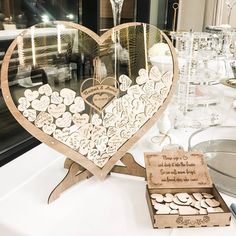 there is a heart shaped display on the table with wine glasses and other items in front of it