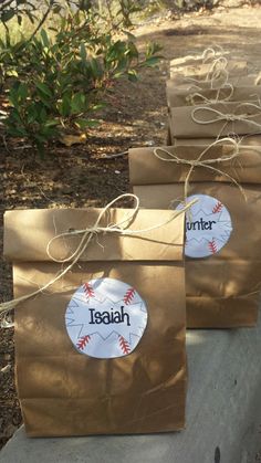 three brown paper bags with baseball designs on them