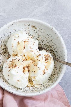 a white bowl filled with whipped cream on top of a pink napkin