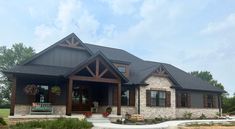 a large house with stone and wood trimmings on the front door, windows, and porch