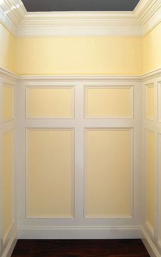 an empty room with yellow walls and white trim on the ceiling is seen in this image