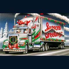 a large semi truck decorated for christmas driving down the road with an american flag on it's side