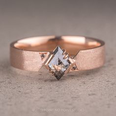 a close up of a ring with a diamond in it on a gray surface,